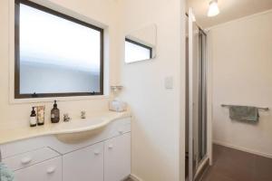 a bathroom with a sink and a large window at The Raukawa Cottage in Tauranga