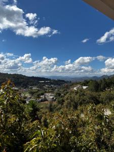 a view of a city from a hill with trees at Mr Lapin in Santiago Sacatepéquez +9 photos