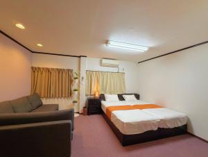 a hotel room with a bed and a couch at Ema-長吉 in Osaka