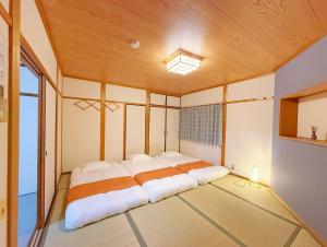 a large bed in a room with a wooden ceiling at Ema-長吉 in Osaka
