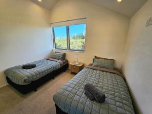 a bedroom with two beds and a window at Fern View - Cozy 2-bedroom house in Hokitika