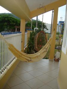 a hammock on a porch with a fence at Casa de Praia em Palmas in Governador Celso Ramos