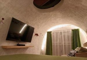 a bedroom with a tv on a wall with a window at Mr Lapin in Santiago Sacatepéquez