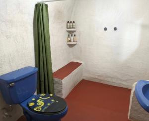 a bathroom with a blue toilet and a shower at Mr Lapin in Santiago Sacatepéquez