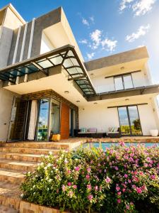 a house with flowers in front of it at Lakeview Bellemare Villa in Belle Mare