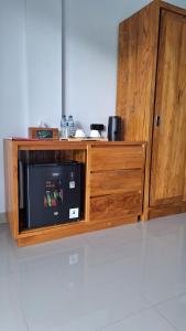 a wooden cabinet with a microwave in a kitchen at Anantalla Homestay in Sidemen