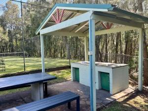 a picnic shelter with a bench in a park at Fathoms 5 - 2BR beach resort apartment in Mollymook