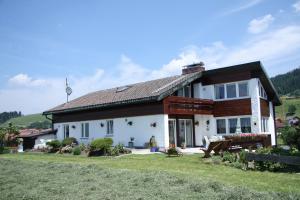 ein weißes Haus mit braunem Dach in der Unterkunft Ferienwohnungen Fricker in Oberstdorf