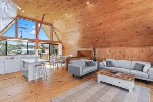 a living room with a couch and a table at Sea-renity in Kioloa