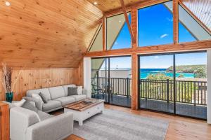 a living room with a couch and a table at Sea-renity in Kioloa