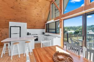 a kitchen and dining room with a large window at Sea-renity in Kioloa