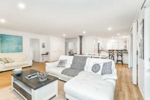 a living room with a white couch and a table at The Salty Deck in Narrawallee