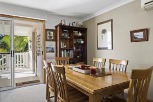 a dining room with a wooden table and chairs at Jillby's House - 3 BR home near Narrawallee Beach in Narrawallee