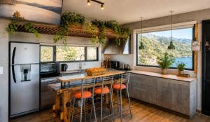 a kitchen with a island with bar stools at Lakefront, Jacuzzi and Pool in San Carlos de Bariloche