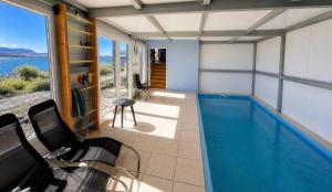 a house with a swimming pool with a view of the water at Lakefront, Jacuzzi and Pool in San Carlos de Bariloche
