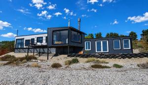 a house on the beach with a lot of windows at Lakefront, Jacuzzi and Pool in San Carlos de Bariloche