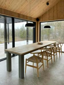 a dining room with a wooden table and chairs at Architect-Designed House In Etelhem, Gotland in Stånga