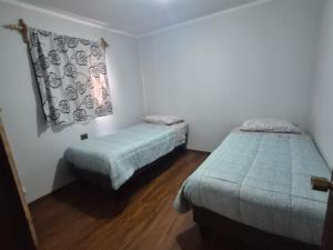 a bedroom with two beds and a window in it at cabañas don Jose in Pucón