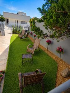 a yard with three chairs sitting on a lawn at Flat Completo - Cozinha - Lavadora - Climatizado in Erval dʼOeste