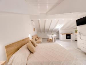 a living room with a large bed and a kitchen at Brand new attic studio apartment, air conditioned in Castelsardo