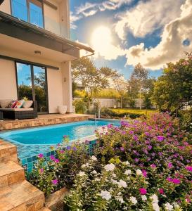 a house with a swimming pool and flowers at Lakeview Bellemare Villa in Belle Mare