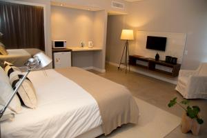 una camera d'albergo con letto e TV di Hotel Zentiva Pinamar a Pinamar