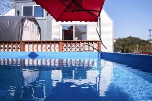 a red umbrella sitting on top of a swimming pool at Yeosu Maru Pension in Yeosu