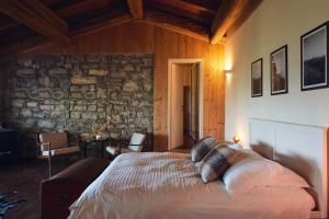 a bedroom with a bed and a stone wall at Ancient Monastery In The Lariani Mountains in Cernobbio +31 photos