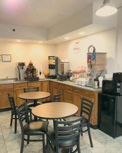 a restaurant with two tables and chairs in a kitchen at Super 8 by Wyndham Groton in Groton