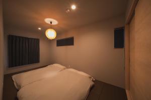 a bedroom with a white bed and a light at 湯宿 蒼の月 in Oita