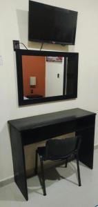 a black desk with a mirror and a chair at hotel del valle in Coatzacoalcos