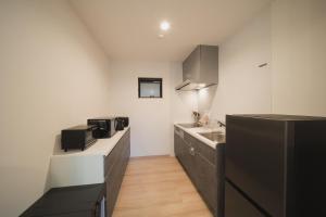 a kitchen with black cabinets and a sink at 湯宿 蒼の月 in Oita +19 photos
