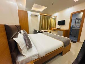 a hotel room with a bed and a television at Hotel Vaishnavi Heights in Aurangābād