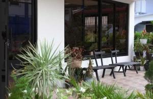 a patio with benches and plants in front of a building at SanRosa Boutique Hotel BnB in Bulalakao