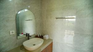 a white bathroom with a sink and a mirror at Bale Sidi House Ubud in Ubud +28 photos