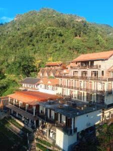 a group of buildings in front of a mountain at Views Backpackers Hostel in Nongkhiaw