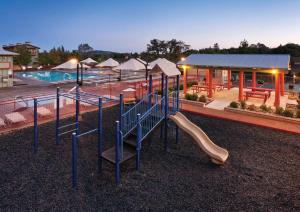 a playground with a slide in front of a pool at Angels Camp Resort 3BR Apartment in Angels Camp