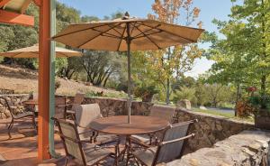 a table and chairs with an umbrella on a patio at Angels Camp Resort 3BR Apartment in Angels Camp