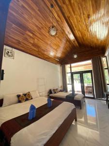a bedroom with two beds and a wooden ceiling at Views Backpackers Hostel in Nongkhiaw