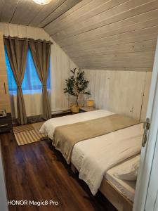a bedroom with a large bed and a window at Cabana Denny in Mărişel