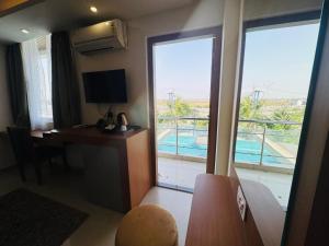 a hotel room with a desk and a view of a pool at Hotel Vaishnavi Heights in Aurangābād