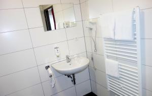 a white bathroom with a sink and a mirror at Budget Hotel Ludwigshafen in Ludwigshafen am Rhein +18 photos