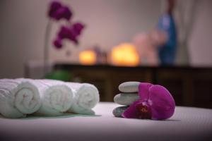 a pile of towels and a purple flower on a table at The Donatello Resort Studio Apartment in San Francisco