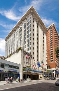 a large white building on a city street with flags at The Donatello Resort Studio Apartment in San Francisco