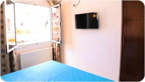 um quarto com uma cama e uma televisão na parede em Hotel Métropole Résidence em Tunes