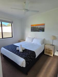 a bedroom with a large bed with white sheets at Kingston Foreshore Caravan Park in Kingston South East