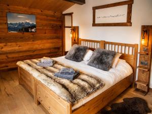 a bedroom with a wooden bed with two pillows at Chalet Sandy in Les Gets