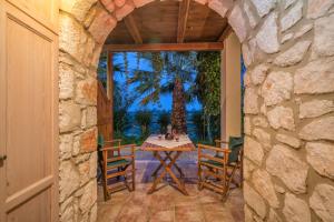 an entrance to a patio with a table and chairs at Myrties stone houses - Ta Petrina in Vasilikos