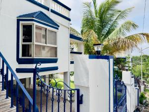 a blue and white house with a gate and a palm tree at Spellbound in Wadgaon