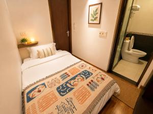 a small room with a bed and a toilet at Giang Ninh Hotel - Korean Town Bac Ninh in Bồ Sơn